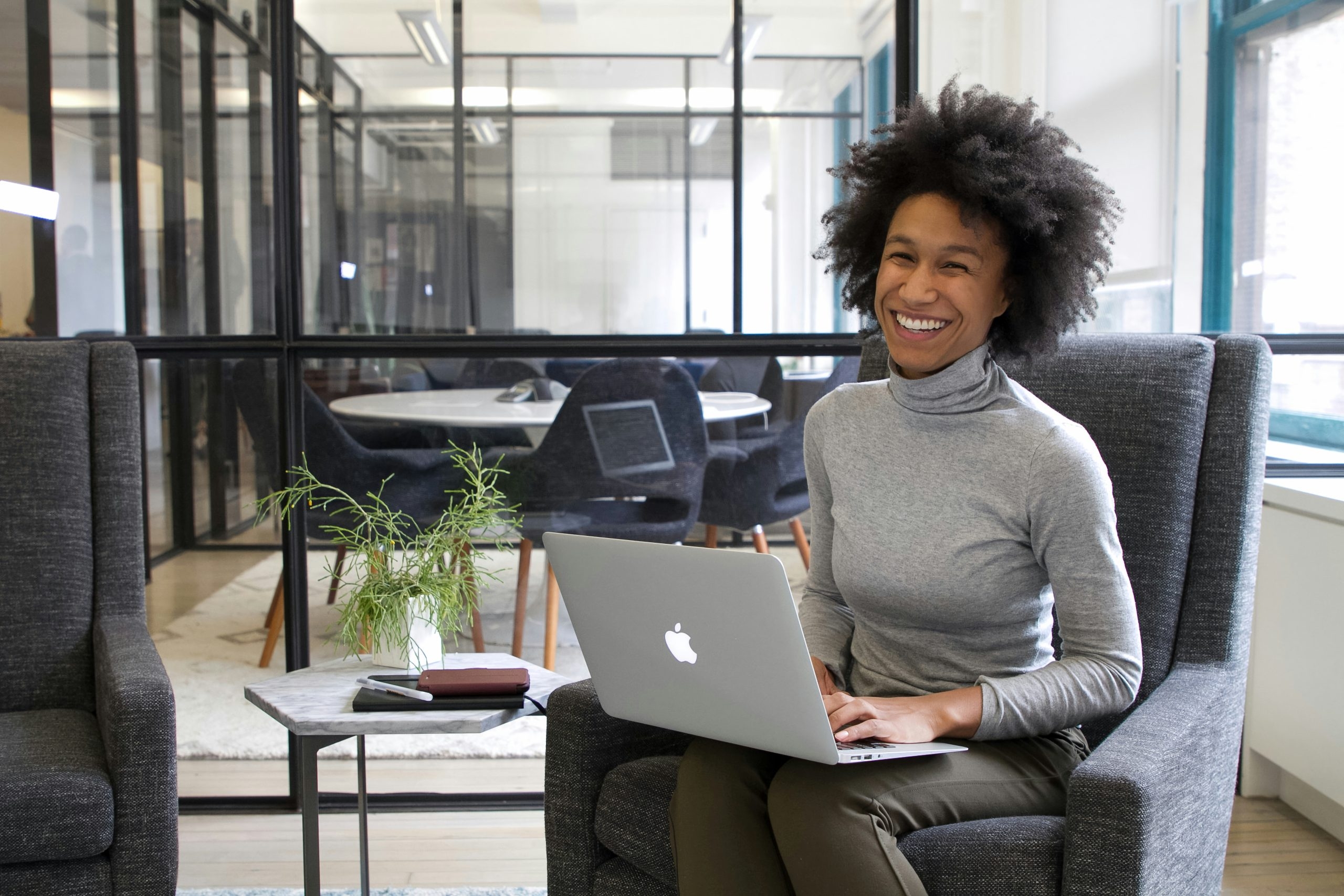 a business owner sat in a chair with a laptop on their lap